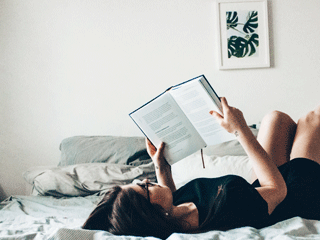 Woman Reading a Gripping Novel in Bed